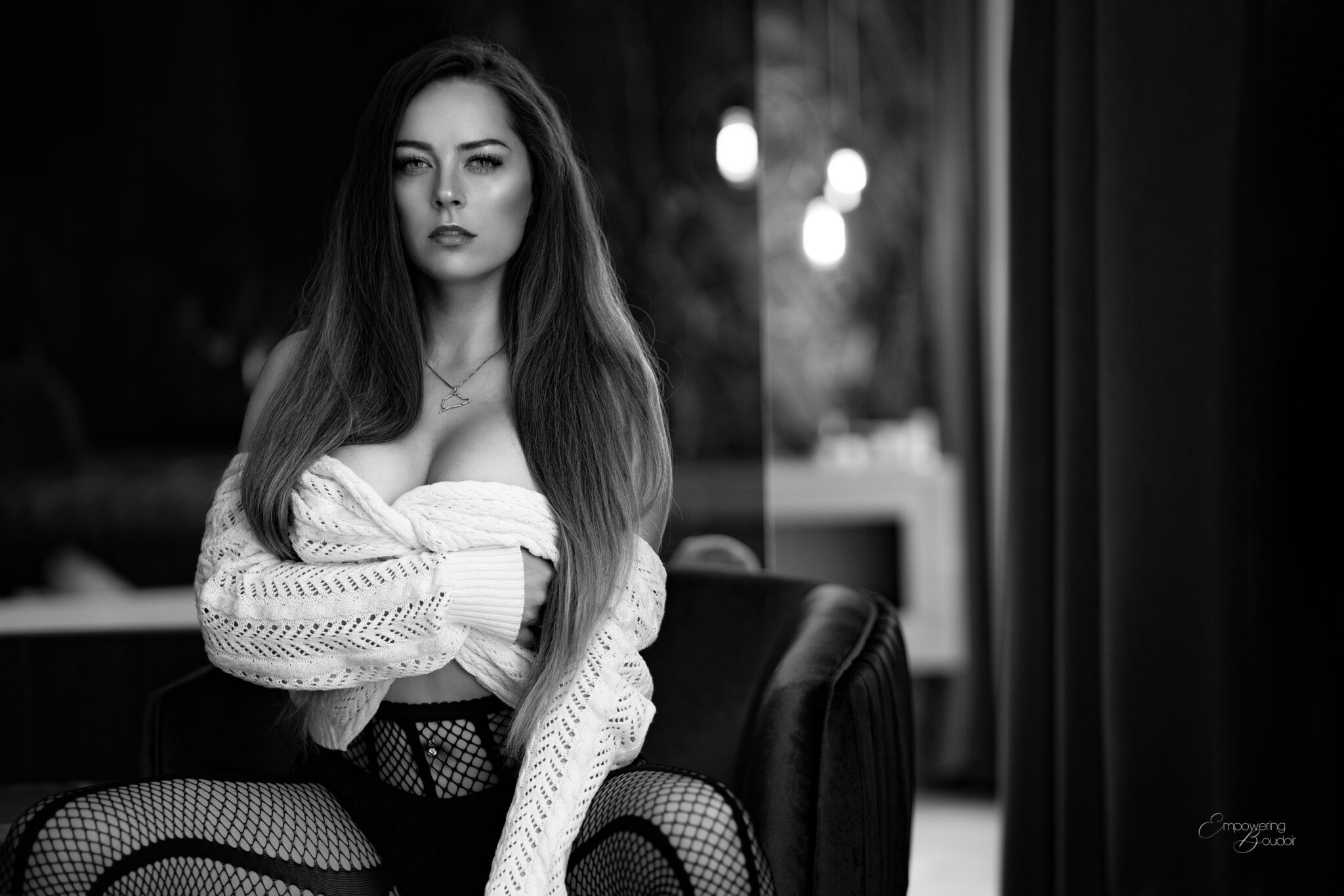 Vrouw met lang haar in een witte gebreide trui, zelfverzekerd in de camera kijkend